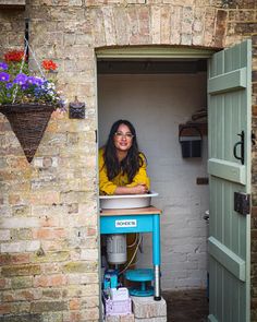 a woman sitting at a table in an open doorway