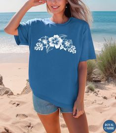 🌺🌸Discover our Tropical Hibiscus flower Comfort Colors unisex shirt This Hibiscus pattern t-shirt features an eye-catching white graphic design. Made of 100% ring-spun ethically grown cotton, this shirt is super soft and comfortable. It has a relaxed fit which is made of a medium fabric that is preshrunk. Looks super cute with shorts or jeans or size up 1-3 sizes for an oversized beach coverup. Great gift for a Beach Lover! Comes in 13 pretty colors! 💠PRINT: This is a handmade, Direct-to-Garm Hawaiian Floral Print Shirt For Beach Season, Summer Hawaiian Shirt For Surfing, Tropical Hawaiian Shirt With Graphic Print For Vacation, Tropical Beach Shirt With Hibiscus Print, Beach Shirt With Hibiscus Print, Hibiscus Print Shirt For Beach Season, Beach Season Hibiscus Print Shirt, Casual Hawaiian Shirt With Hibiscus Print For Beach Season, Hawaiian Shirt For Beach Season