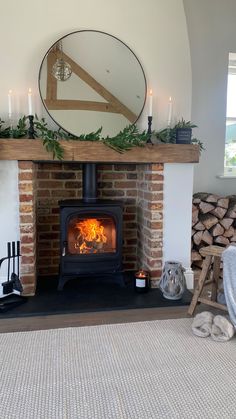 a living room with a fire place in the middle and candles on the fireplace mantel