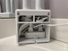 an electrical outlet in the middle of a sink with wires and plugs attached to it