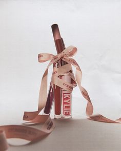 a tube of lip glosses tied up with a brown ribbon and some words on it