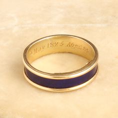 This unassuming gold and blue enamel ring is so much more than meets the eye. Dating to the Regency period, this elegant piece is mourning ring engraved with the following details: "J. D. died 24th May 1825 Aged 84." The interior golds a hinged locket which once would have held plaited hair of the deceased but is now empty. This style of concealed locket mourning ring is quite unusual and very very special. It is a size 6 and cannot be resized. ((details)) Materials: 18k yellow gold, blue enamel