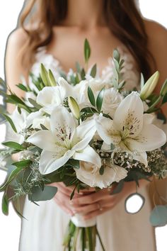 a woman holding a bouquet of white flowers