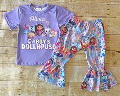 two children's pajamas and t - shirt with cartoon characters on them sitting on a wooden floor