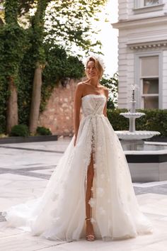 a woman in a wedding dress standing on the street