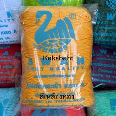 several different colored yarns in bags on display for sale at a market stall, with the words kakabath printed on them