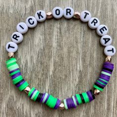 Includes one beaded bracelet with white/black letter beads spelling "Trick Or Treat" with purple, black, and green clay heishi beads and gold spacer accent beads. This bracelet is made using stretchable elastic tied to fit most wrists. Halloween Beaded Bracelets With Letter Beads, Purple Heishi Beaded Bracelets With Letter Beads, Purple Heishi Beads Bracelet With Letter Beads, Halloween Clay Braclets, Personalized Halloween Beaded Bracelets, Halloween Themed Handmade Beaded Bracelets, Handmade Themed Halloween Bracelet, Disney Bracelet, Bracelets Design