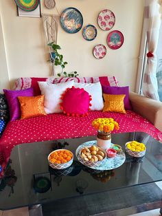 a living room filled with lots of furniture and plates on the wall above it's glass coffee table