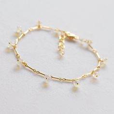 This delicate chain bracelet has a kind of gossamer look. It is designed with gold filled bar chain adorned with smooth polished roundels of milky Ethiopian opals with just a touch of fire . All of the gems are wrapped on gold filled ball head pins and dance around the length of the bracelet. 7.25 inches long with 1 inch extender, this bracelet closes with a lobster style clasp. Perfect layering bracelet, beautiful gift. I imagine it perfect for a bride. This style bracelet is available with pin Delicate Gold Plated Bracelet With Chain, Dainty Gold Bracelet With Extender, Minimalist Adjustable Chain Charm Bracelet For Wedding, Dainty Gold Plated Bracelet With Extender, Minimalist Charm Bracelet With Adjustable Chain For Wedding, Delicate Gold-plated Charm Bracelet, Delicate Gold Charm Bracelet, Dainty Gold Rosary Bracelet With Adjustable Chain, Delicate Yellow Gold Bracelets With Delicate Chain