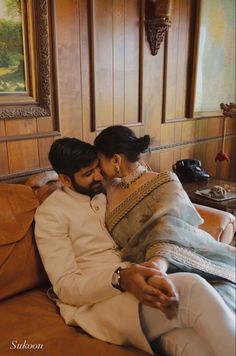 a man and woman sitting on top of a couch