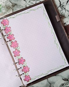 an open notebook with pink flowers on it