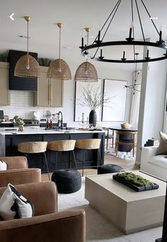 a living room filled with furniture next to a kitchen