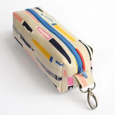 a multicolored zipper pouch with a keychain hanging from it's side