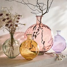 three different colored vases with flowers in them