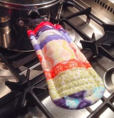 an oven mitt sitting on top of a stove