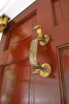 a door handle on a red wooden door