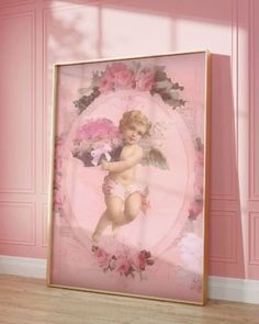 a framed photograph of a baby in diapers with pink flowers on the wall behind it