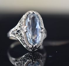 Light sky blue aquamarine shaped as an elongated oval. Set in a classic edwardian filigree lace setting. In excellent condition. Size 5.5, sizeable Art Deco Oval Filigree Ring For Formal Occasions, Oval Art Deco Filigree Ring For Formal Occasions, Oval Art Deco Filigree Ring Formal, Formal Oval Filigree Ring With Diamond Cut, Oval Diamond Cut Filigree Ring For Formal Occasions, Formal Oval Engraved Filigree Ring, Art Deco Oval Filigree Ring With Gemstone, Art Deco Oval Filigree Ring With Diamond Cut, Antique Oval Topaz Ring For Formal Occasions