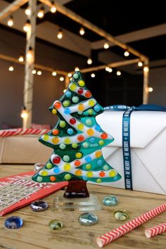 a small christmas tree sitting on top of a wooden table next to candy canes