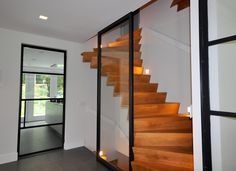 the stairs in this house are made of wood and glass, with lights on each side