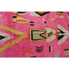 a pink rug with colorful designs on it