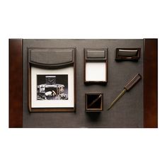 an assortment of items displayed on a table including pen, ink roller and photo frame