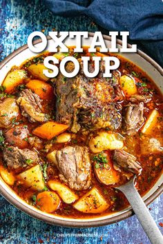 a bowl of oxtail soup with potatoes and carrots in it on a blue table cloth