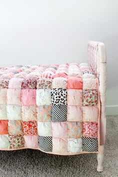 a pink bed with lots of different colored squares on it