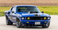 a blue muscle car parked in a parking lot