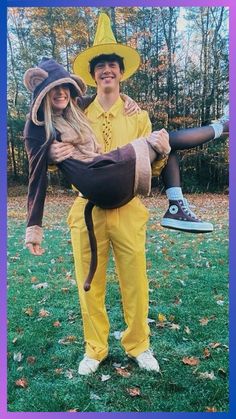 a man and woman dressed up in costumes for halloween, one is carrying a cat