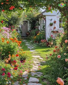 a garden with lots of flowers and plants in the front yard, along with a stone path that leads to a small white building