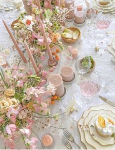 the table is set with pink flowers and candles