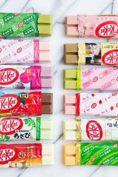 six different types of candy bars lined up on a marble counter top with japanese writing