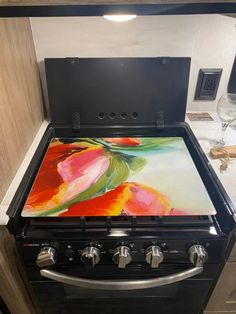 a stove top oven sitting inside of a kitchen next to a wine glass and bottle