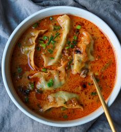 a white bowl filled with pasta and meat in tomato sauce, garnished with parsley