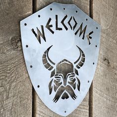 a metal sign that reads welcome with a horned head on it's side and the words,