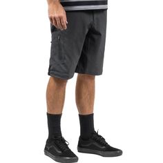 a man in black shorts and socks is standing with his hands on his hipss