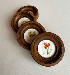 four wooden buttons with flowers in them on a white surface