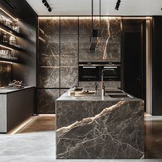 an elegant kitchen with marble counter tops and black cabinets, along with dark wood shelves