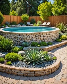 an outdoor pool surrounded by rocks and succulents in the middle of a garden