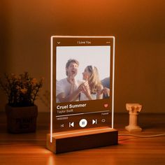 a wooden stand with an mp3 player on it and a flower pot in the background