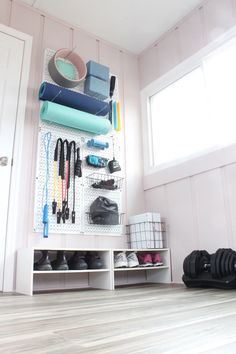 there is a white shelf with many items on it and shoes hanging up against the wall