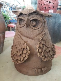 a clay owl statue sitting on top of a table