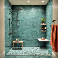 a walk in shower sitting next to a toilet and a bath room with blue tiles on the walls