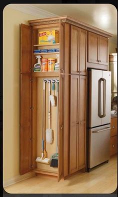 a kitchen cabinet with cleaning supplies in it