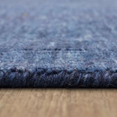 a close up view of a blue rug on a wooden floor