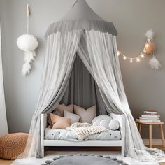 a canopy bed with white drapes and pillows in a gray bedroom decorated for christmas