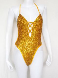 a mannequin wearing a gold bodysuit with sequins