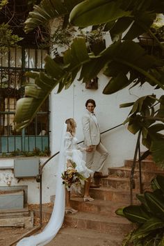 a bride and groom walking down the stairs