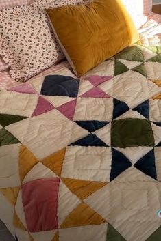 a bed with a colorful quilt and pillows on it